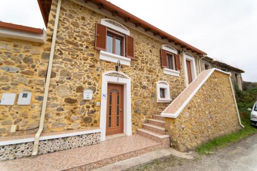a stone building with a door and stairs on it at Casa Torre das Andorinhas in Nazaré