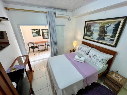 a bedroom with a bed and a balcony with a table at Suíte Lavanda Cama & Café - Centro, Marechal Floriano-ES in Marechal Floriano