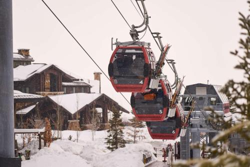two skiers are riding on a ski lift in the snow at Waldorf Astoria Park City in Park City