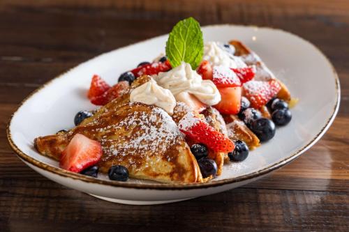 a plate of french toast with fruit on a table at Waldorf Astoria Park City in Park City