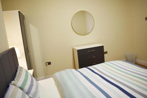 a bedroom with a bed and a dresser and a mirror at Birmingham City Centre Room in edgbaston near stadium, Free Parking in Birmingham