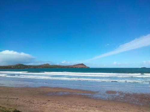 a beach with the ocean and mountains in the background at Murphy's Guesthouse in Dingle