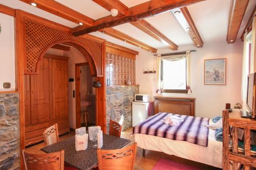 a room with a bed and a table and a kitchen at Casa Rural Restaurant Borda Patxeta in Canillo