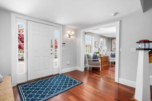 a living room with a white door and a blue rug at 14 Hallet Lane Chatham Cape Cod - - Sand Simeon in Chatham