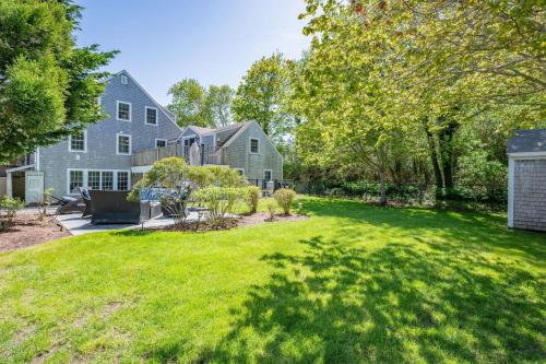 a yard with green grass and a house at 14 Hallet Lane Chatham Cape Cod - - Sand Simeon in Chatham