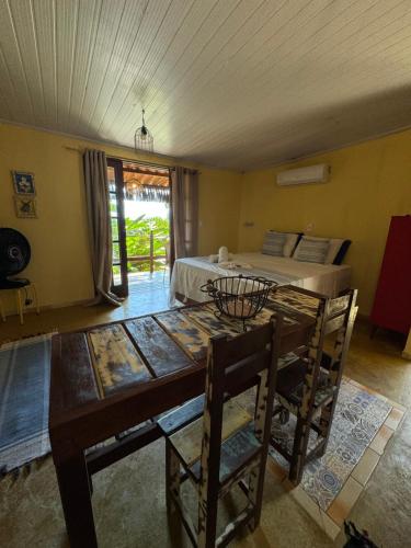 uma sala de jantar com uma mesa e uma cama em Chalé Maria Bonita - Ilha Grande, RJ em Angra dos Reis