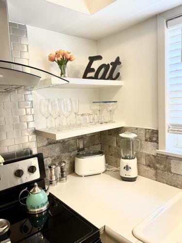 a kitchen with a counter with glasses on shelves at The Garden Room at Galleria in Houston