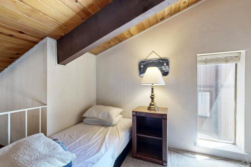 Dormitorio pequeño con cama y lámpara en Katherine Court Townhouse en Stateline