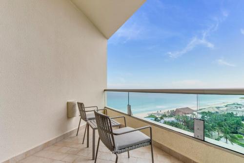 a balcony with chairs and a large window at Live Aqua Cancun - Adults Only - All-Inclusive in Cancún