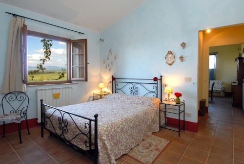 a bedroom with a large bed and a window at Tenuta Santagnese in Montepulciano