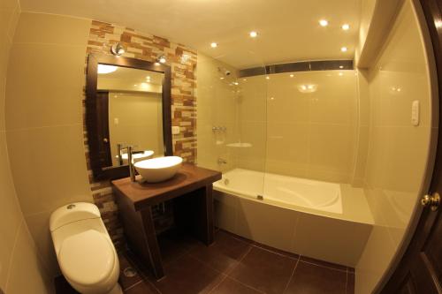Un baño con lavabo, bañera e inodoro. en La Estancia de la Abuela Cusco Hotel, en Cusco
