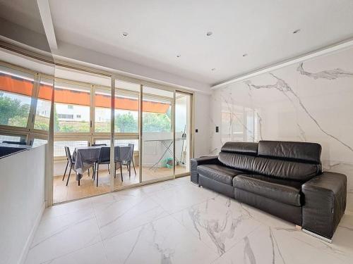 un salon avec un canapé en cuir et une table dans l'établissement 2 pièces 35 m2 + 1 véranda, à Antibes