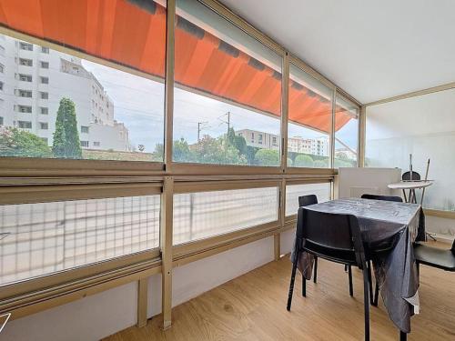 une salle à manger avec une table et une grande fenêtre dans l'établissement 2 pièces 35 m2 + 1 véranda, à Antibes