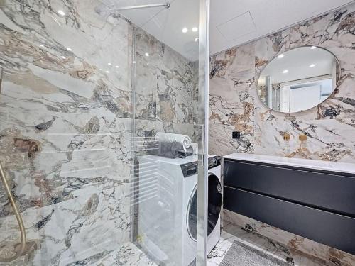 La salle de bains est pourvue d'une douche, d'un lavabo et d'un miroir. dans l'établissement 2 pièces 35 m2 + 1 véranda, à Antibes