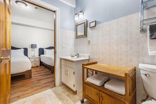 uma casa de banho com um lavatório, um WC e uma cama em Majestic Hotel em Ocean Grove