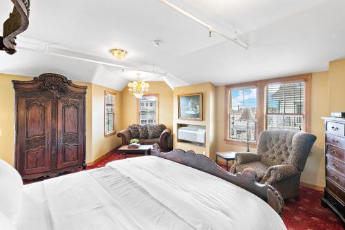 a bedroom with a large bed and two chairs at Majestic Hotel in Ocean Grove