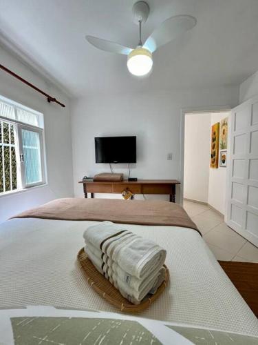 a white bedroom with a bed with a fan at Cantinho Ítalo-Germânico Hospedagem - Suíte Girassol - Centro, Marechal Floriano-ES in Marechal Floriano