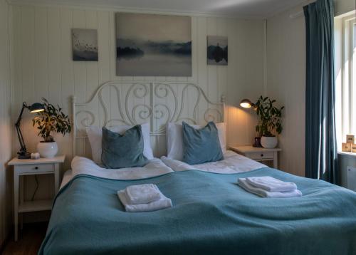 a bedroom with a blue bed with towels on it at Fjellhagen in Bjørkheim