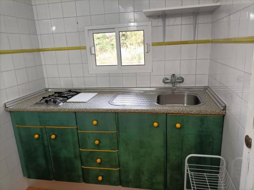 a small kitchen with a sink and a window at El Palomar Rooms Tarifa in Tarifa