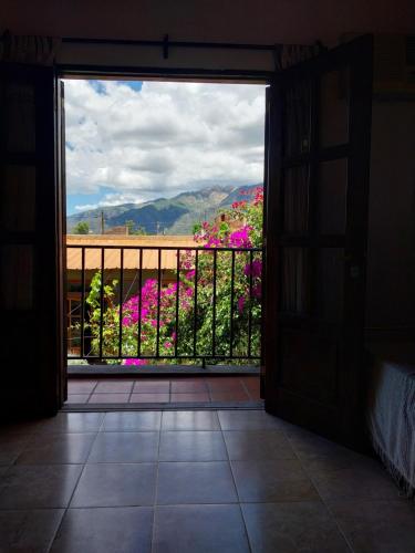 una puerta abierta a un balcón con flores rosas en Lo de Mora, en Cafayate