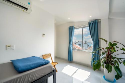 Cette chambre comprend un lit et une fenêtre. dans l'établissement Hoi An Love.Ly Hostel, à Hội An