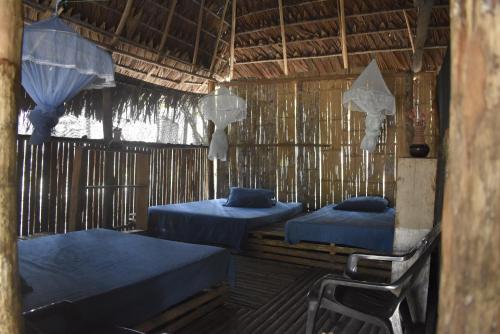 a room with two beds in a straw hut at Toninas Hotel in Inírida