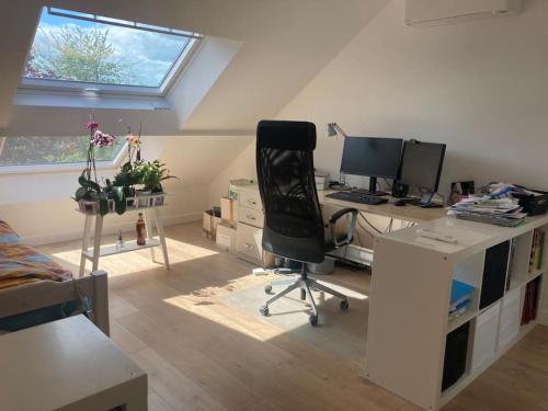 une pièce avec un bureau avec un ordinateur et une chaise dans l'établissement Grande Maison aux portes de Paris JO 2024, à Houilles