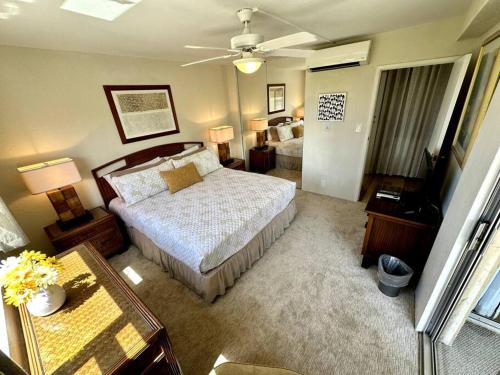 a bedroom with a bed and a table and a couch at Beautiful Oceanfront, AC In Each Room, Sleeps 6 in Kihei