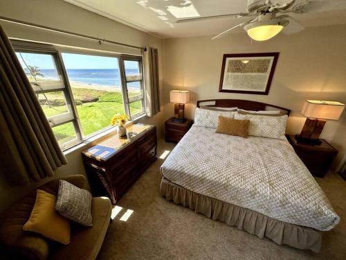 a bedroom with a bed and a large window at Beautiful Oceanfront, AC In Each Room, Sleeps 6 in Kihei