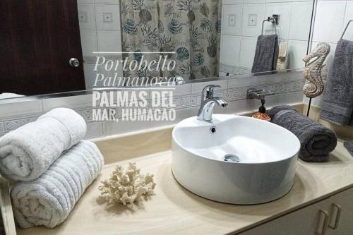 y baño con lavabo y toallas en la encimera. en Portobello Palmanova, Palmas del Mar, Humacao, PR, en Humacao
