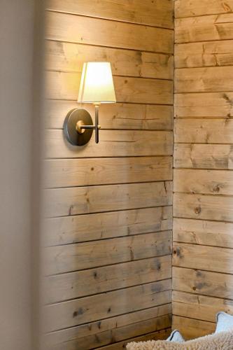 a room with a wooden wall with a lamp at Stylish Tiny Home with Fire Pit in Moss Vale in Moss Vale