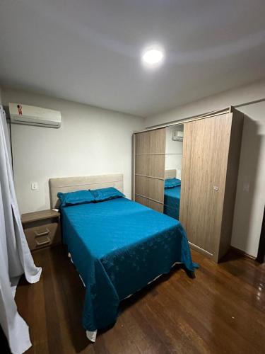 a bedroom with a blue bed and a closet at Apartamentos Nadai 302 in Foz do Iguaçu