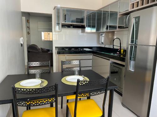 uma cozinha com uma mesa e cadeiras e um frigorífico em Ap202 - Residencial Garves em Patos de Minas