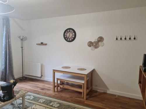 une pièce avec une table et une horloge au mur dans l'établissement Appartement saint ouen 45M2, à Saint-Ouen