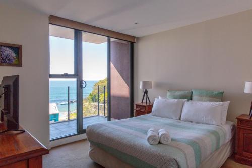 a bedroom with a bed with a view of the ocean at Strand Beachside 903 in Forster