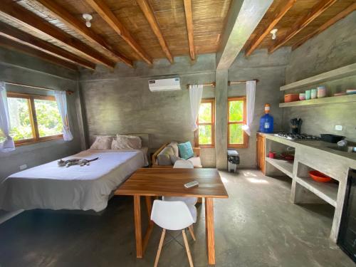 a bedroom with a bed and a wooden table at Hermanos Perdidos Surf in Las Tunas