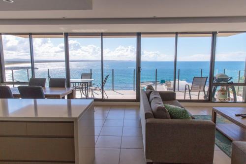 a living room with a view of the ocean at Strand Beachside 903 in Forster