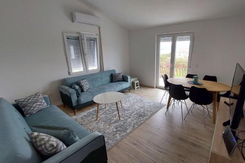 a living room with a blue couch and a table at Apartments by the sea Pasman - 19658 in Pašman