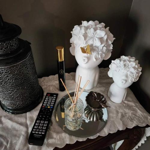 a table with a vase with flowers and a remote control at Bonnie's by Lake Daylesford in Daylesford