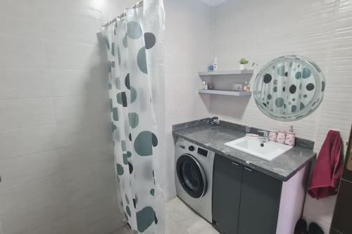 a bathroom with a washing machine and a sink at Tadrart house - Joli Appartement à Agadir in Agadir