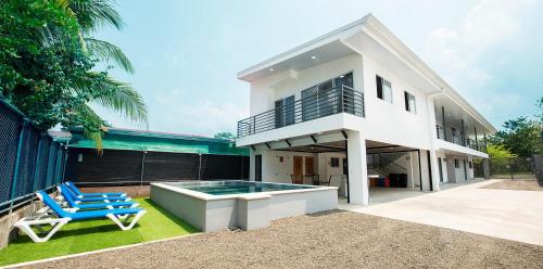 a house with a swimming pool and two blue chairs at SamaraLofts near town and beaches in Sámara