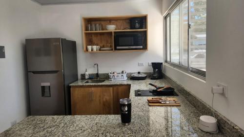 a kitchen with a refrigerator and a counter top at SamaraLofts near town and beaches in Sámara