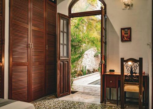 a room with an open door to a garden at Casa Armadillo, colonial house with pool in Mérida