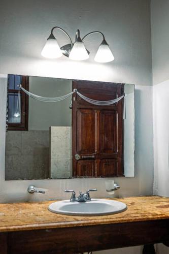 a bathroom with a sink and a mirror at Casa Armadillo, colonial house with pool in Mérida