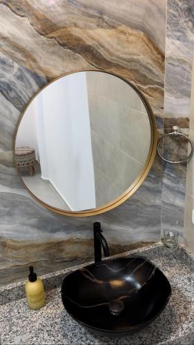 a bathroom with a round mirror over a sink at Hotel Boutique Campestre in Florencia