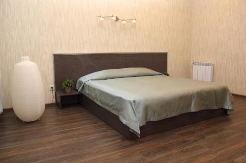 een slaapkamer met een bed en een vaas op de vloer bij Hotel Complex Park hotel D-grad in Dimitrovgrad