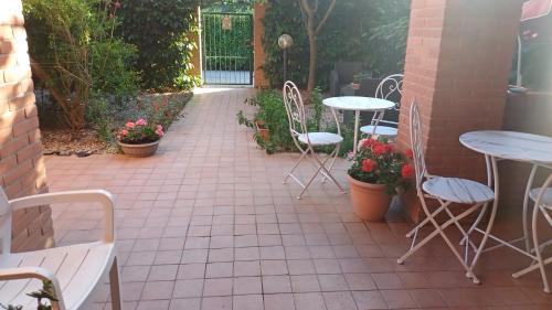a patio with tables and chairs and flowers at La Quercia Fiorita in Trivolzio