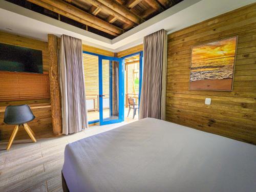 a bedroom with a bed in a room with wooden walls at Hotel Explore Caño Dulce in Tubará