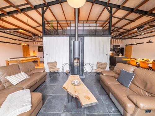 a living room with couches and a wood stove at Elegant Place in Goesnes in Goesnes