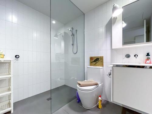a white bathroom with a toilet and a shower at BPM Brighton APT with Garden LG1 in Melbourne